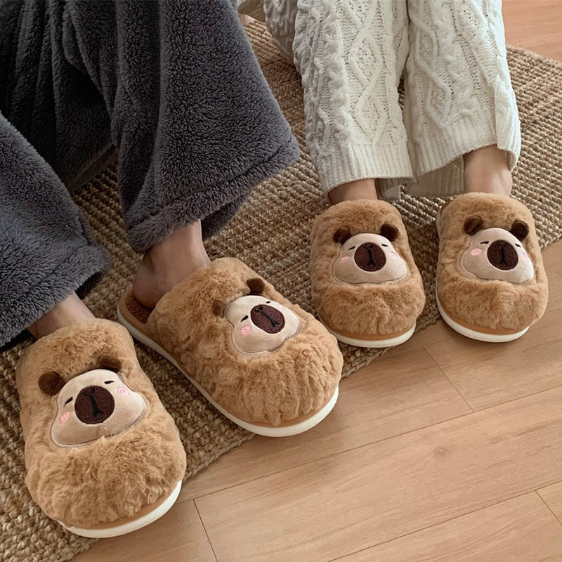 Light brown fuzzy plush slippers showcasing a capybara face with cream patch and dark snout, cozy indoor footwear with PVC sole