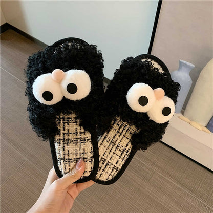 Black curly plush slippers featuring large white protruding eyes and a peach pom-pom, woven footbed indoor footwear with PVC sole