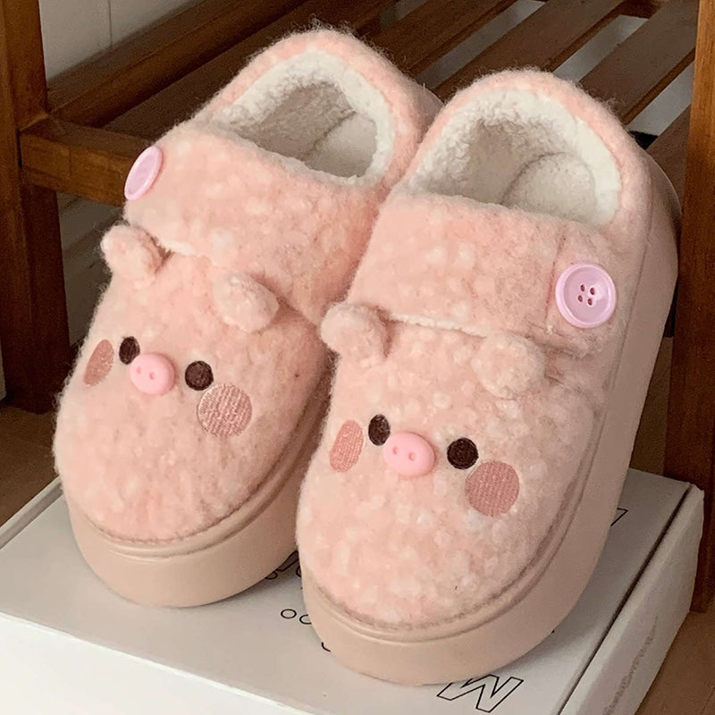 Cute pink pig plush slippers with button accent, pig face with snout and round ears, closed-back fuzzy indoor shoes with EVA sole