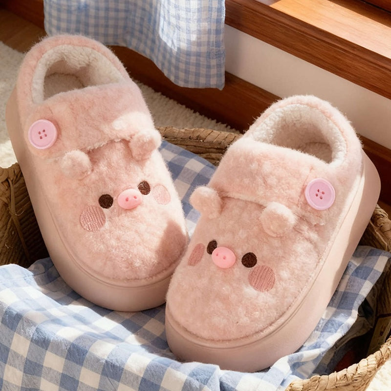 Cute pink pig plush slippers with button accent, pig face with snout and round ears, closed-back fuzzy indoor shoes with EVA sole