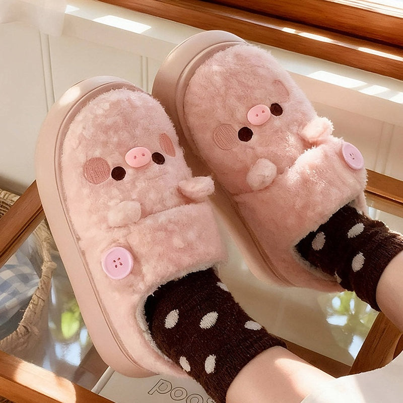 Cute pink pig plush slippers with button accent, pig face with snout and round ears, closed-back fuzzy indoor shoes with EVA sole