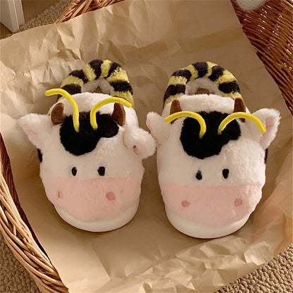 Cute pink cow and bee plush slippers with black patches, yellow stripes, and yellow antennae, closed-back fuzzy indoor shoes with EVA sole