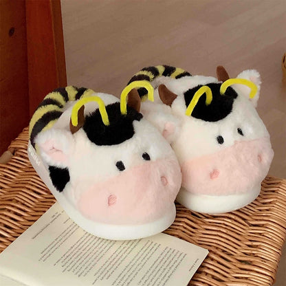 Cute pink cow and bee plush slippers with black patches, yellow stripes, and yellow antennae, closed-back fuzzy indoor shoes with EVA sole