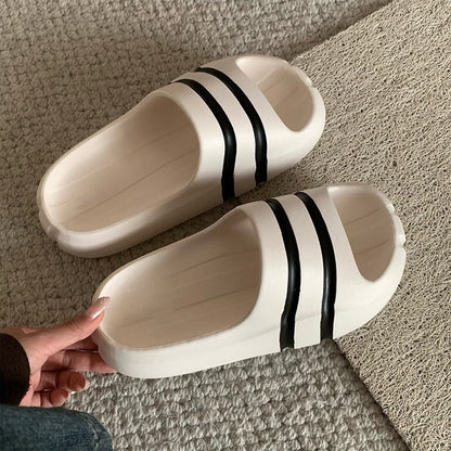 White wide-strap EVA slide sandals with black double stripes, all-EVA low-arch indoor shoes
