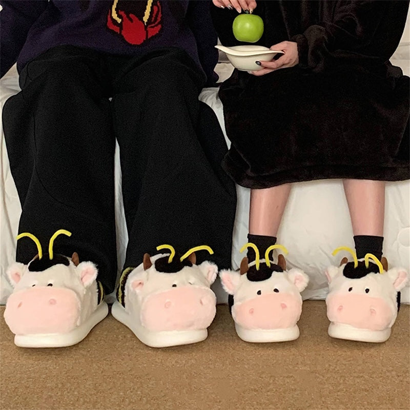 Cute pink cow and bee plush slippers with black patches, yellow stripes, and yellow antennae, closed-back fuzzy indoor shoes with EVA sole