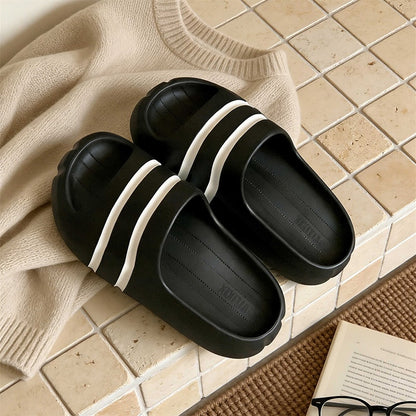 Black wide-strap EVA slide sandals with white double stripes, all-EVA low-arch indoor shoes