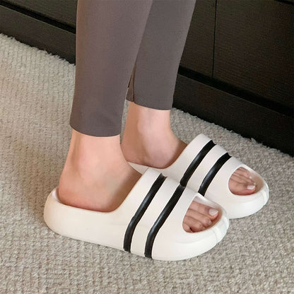 White wide-strap EVA slide sandals with black double stripes, all-EVA low-arch indoor shoes