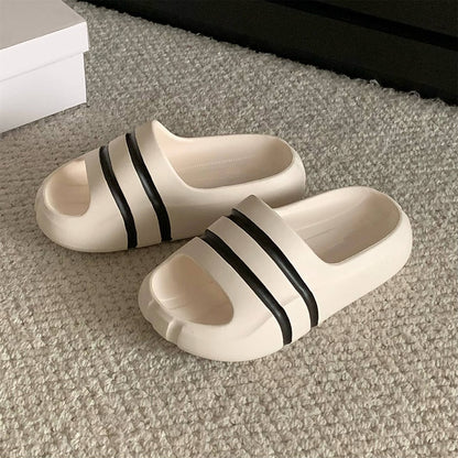 White wide-strap EVA slide sandals with black double stripes, all-EVA low-arch indoor shoes
