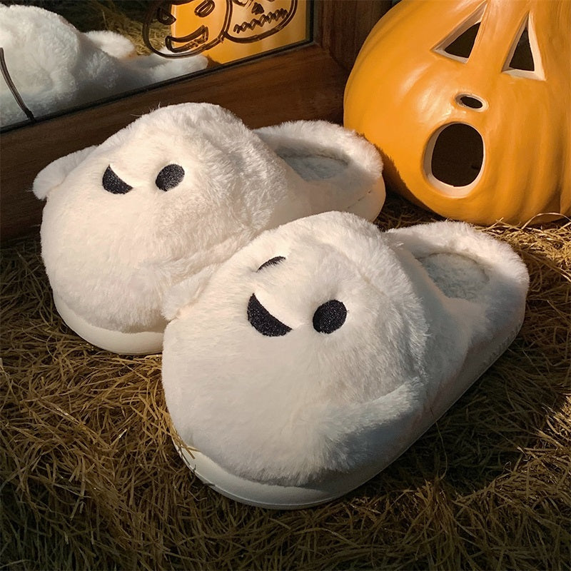 Playful white Halloween ghost face plush slippers featuring black dot eyes and a wavy smile, soft indoor footwear with EVA sole