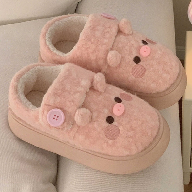 Cute pink pig plush slippers with button accent, pig face with snout and round ears, closed-back fuzzy indoor shoes with EVA sole