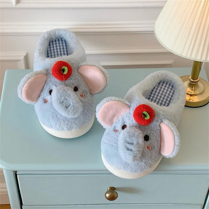 Blue plush elephant slippers with large pink ears and a red apple top decoration, cozy indoor footwear with EVA sole
