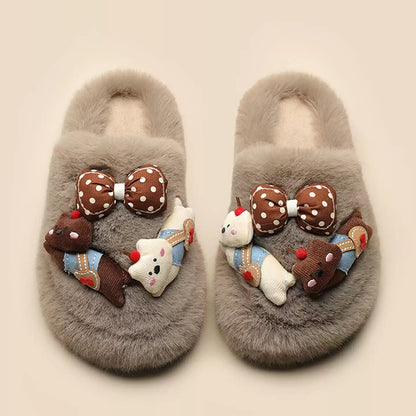 Grey plush slippers featuring a chunky bear with blue suspenders and a large polka-dot bow, cozy indoor shoes with rubber sole