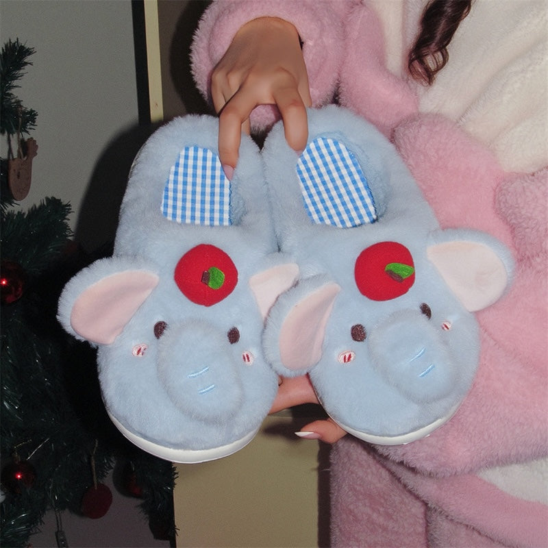 Blue plush elephant slippers with large pink ears and a red apple top decoration, cozy indoor footwear with EVA sole