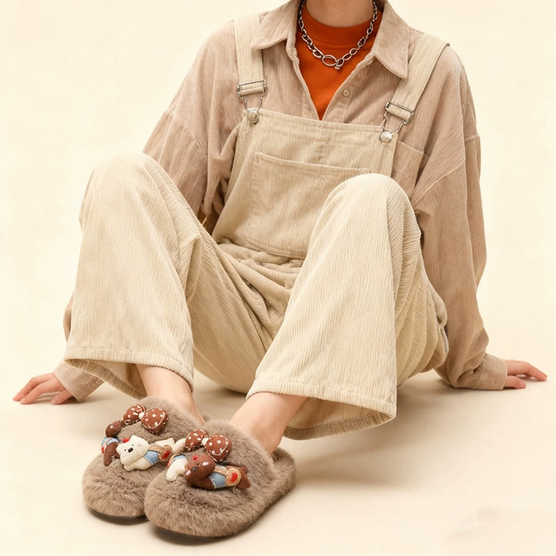 Grey plush slippers featuring a chunky bear with blue suspenders and a large polka-dot bow, cozy indoor shoes with rubber sole